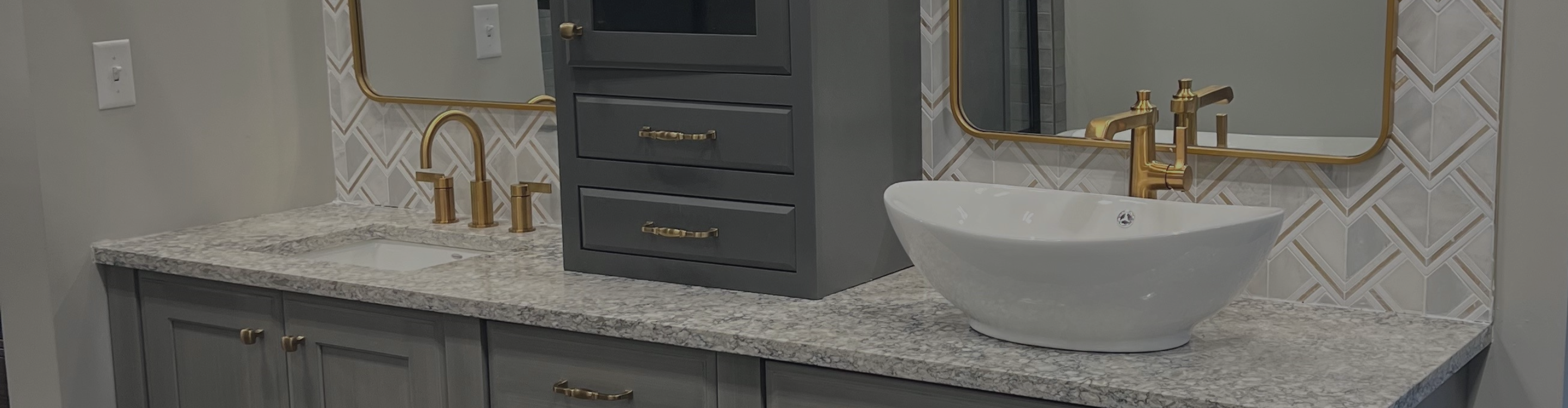 Modern bathroom vanity with gray cabinetry, gold hardware, dual sinks, patterned tiles, dual mirrors, and elegant illuminated lighting for a sophisticated look.