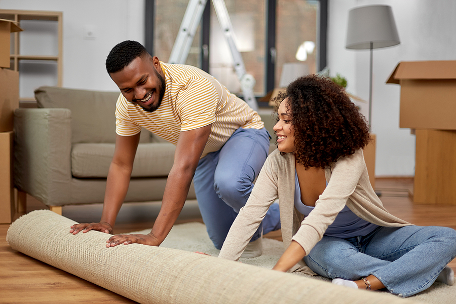 Couple unrolling an area rug